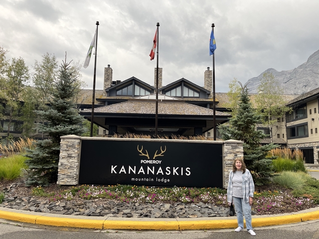       A person standing in front of the Kananaskis Mountain Lodge.
  