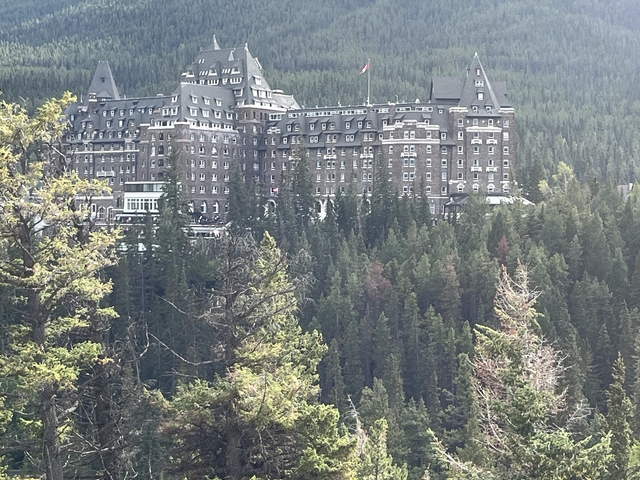 A grand hotel with forested hills behind.