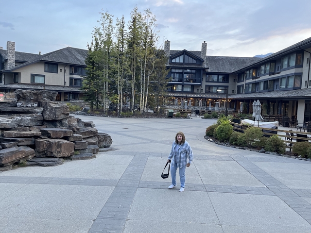       A woman standing in a large courtyard of a lodge.
  