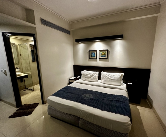 Interior of a hotel room with a bed and bathroom.