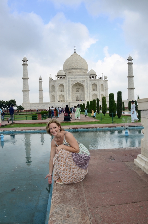 A woman posing in front of the Taj Mahal.