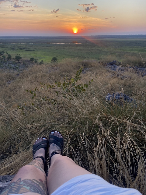 Close-up view of grassy terrain with feet visible.