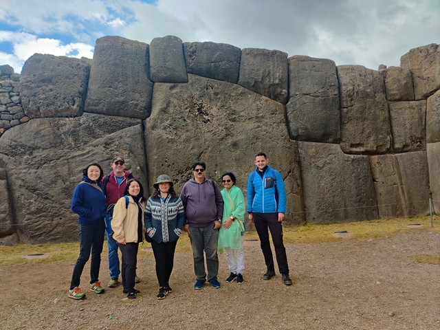       Group posing in front of large ancient stones.
  