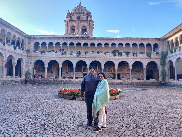       Two people posing in a historical courtyard.
  
