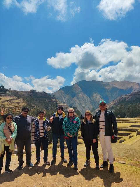       Group of people posing with mountains in the background.
  