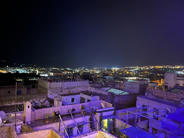       Nighttime aerial view of a city with lit buildings.
  