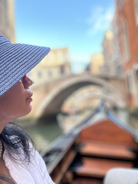       Close-up of a person with a Venetian canal in the background.
  