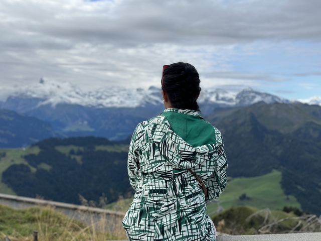 Individual looking out over a picturesque mountain range.