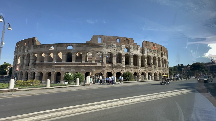       The Colosseum in Rome, viewed from a moving vehicle.
  