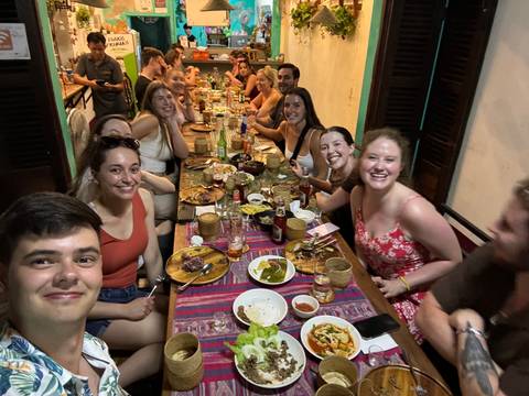 Group of people dining at a table with lots of food.