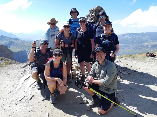 Group of hikers posing on a mountain trail.