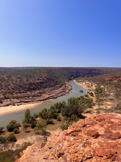       River meandering through a red rocky canyon.
  