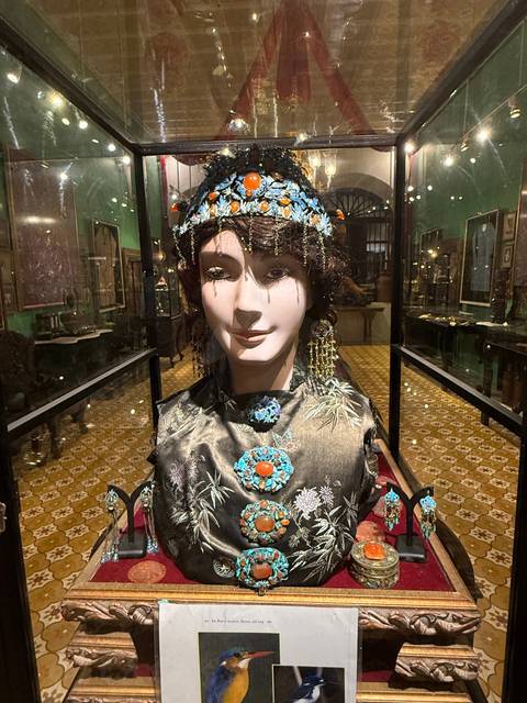Mannequin head with traditional jewelry in a display case.