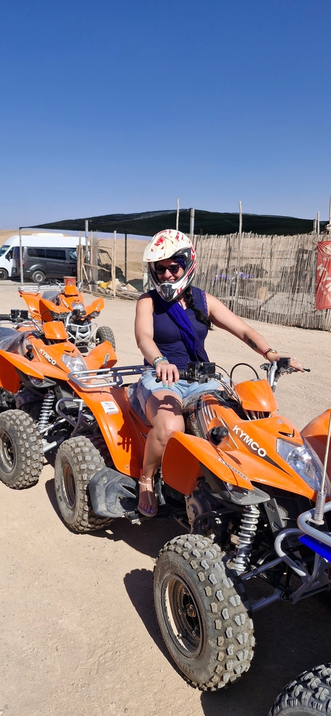       Woman on a quad bike ready to explore.
  