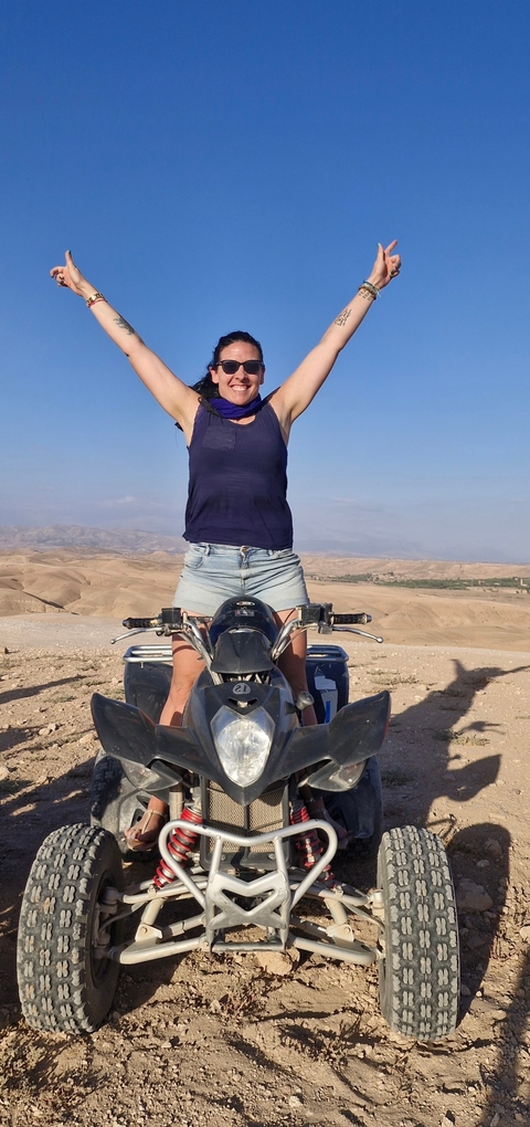       Person on a quad bike in a desert landscape.
  