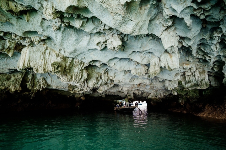 Cave with stalactites and a small boat entering