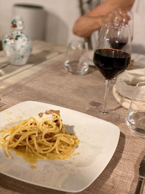       Pasta dish with cheese and a glass of red wine.
  