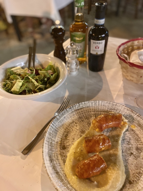       Table setting with salad and sausage dish.
  