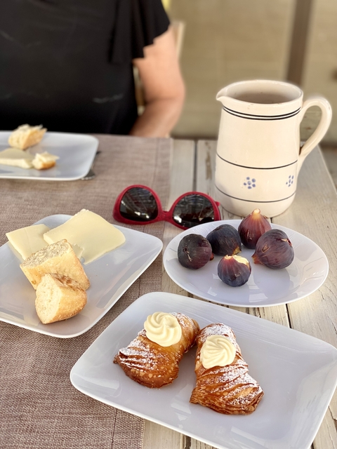       Figs and bread on plates next to sunglasses.
  