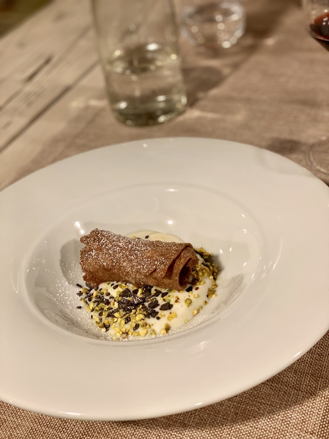       Dessert with cream and pistachios on a white plate.
  