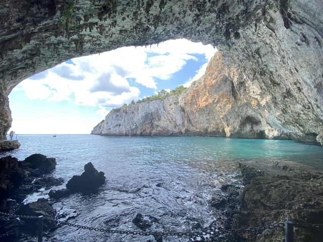       Scenic view from inside a cave looking out to the sea.
  
