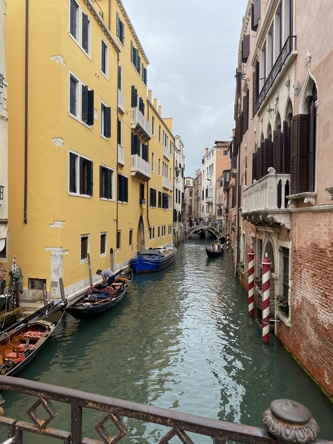 Venetian canal scene with gondolas and historic buildings.
