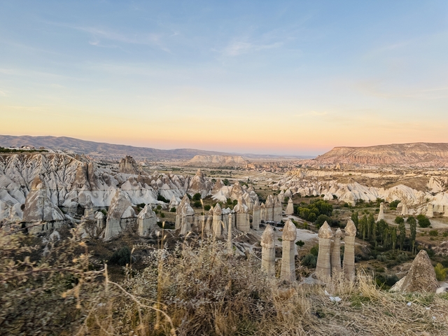       Cappadocia's iconic rock formations under a sunset sky.
  