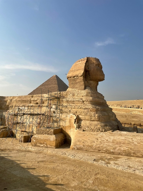      The Sphinx and the Great Pyramid in Giza, Egypt, with scaffolding for restoration work.
  