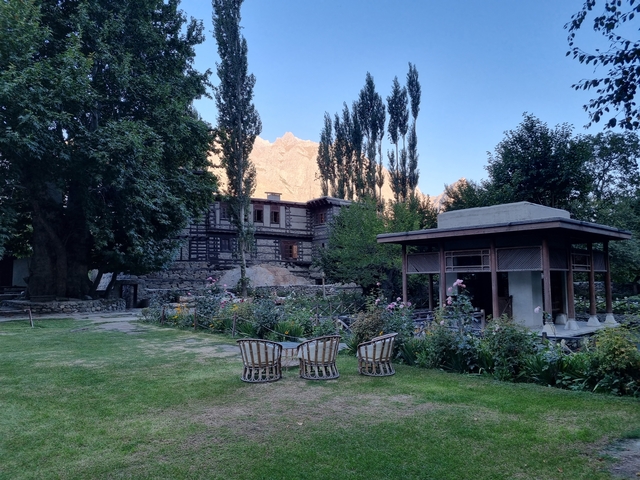Garden area with outdoor seating and traditional stone houses in the background.
