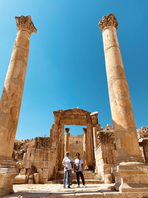 Ancient ruins with stone columns under a bright blue sky.