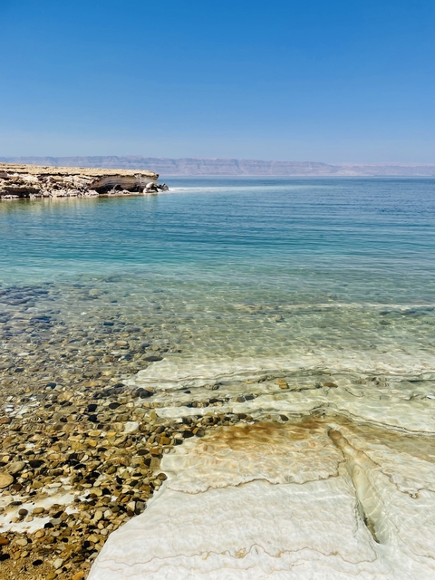 Clear water with rocky shorelines under a sunny sky.