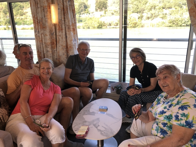 Group of people playing cards on a boat.