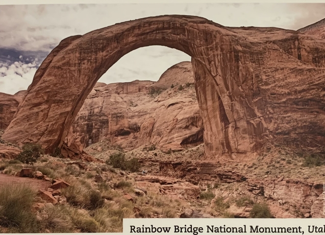 A natural stone arch in a desert landscape.