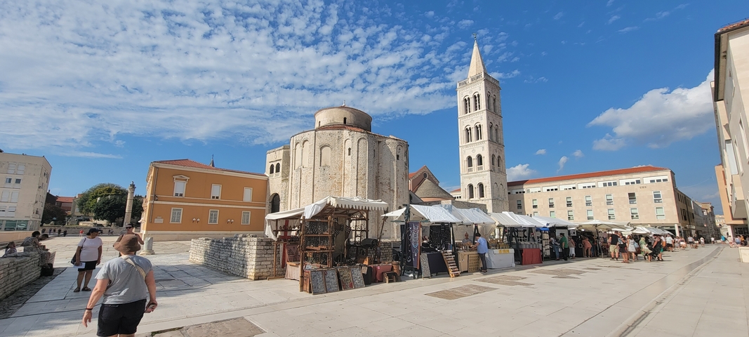 Historic church and street market under a blue sky.