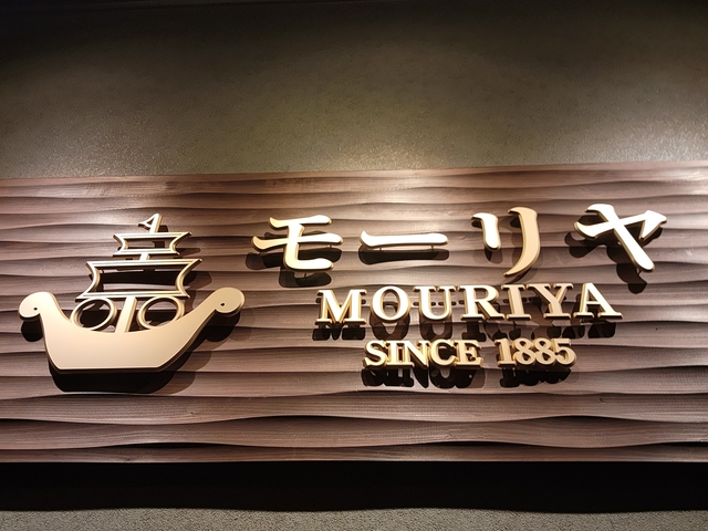 Restaurant sign with Japanese text on a wooden wall.