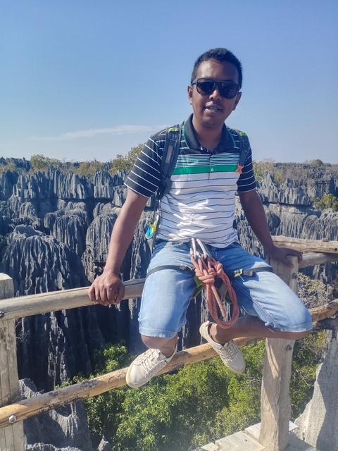 Man sitting in a landscape with unique rock formations.