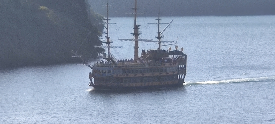 Replica of a pirate ship sailing on a lake.