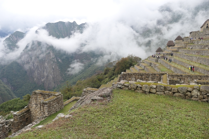 Terraced ancient structures with misty mountain backdrop.