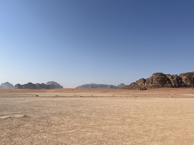 Desert landscape with mountain ridges against a clear sky.