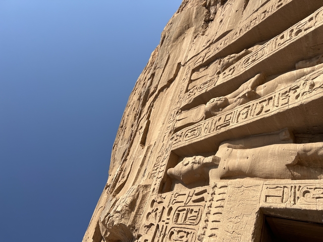       Close-up of hieroglyphics and carvings on an ancient stone wall.
  