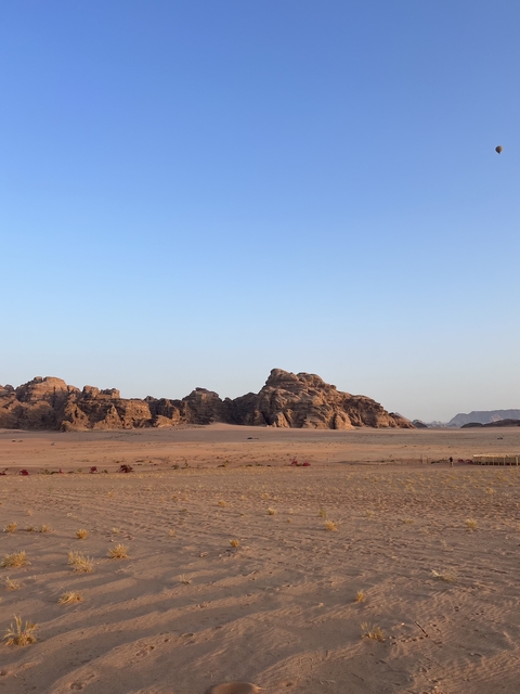       Desert landscape with rocky formations and a clear blue sky.
  