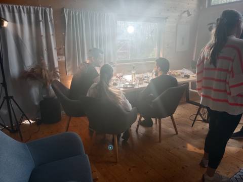 Indoor scene with people sitting at a table, light setting.