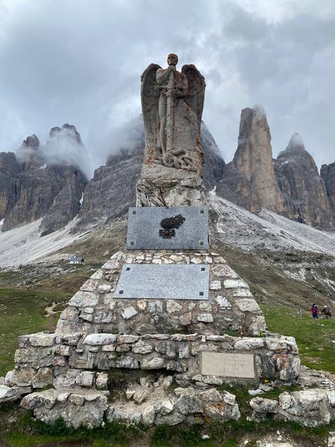 Stone monument with a scenic mountain backdrop.
