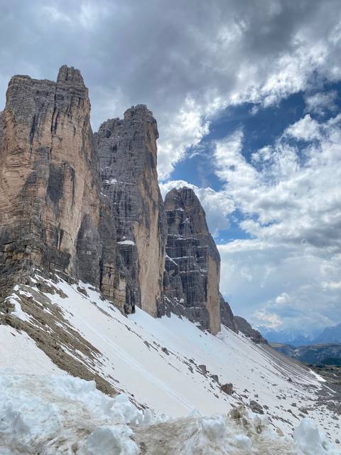 Snow-covered mountain peaks with cloudy sky.