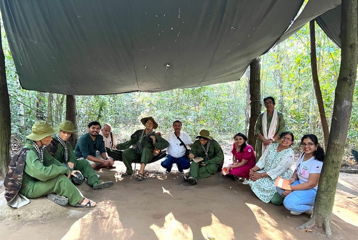       Group posing under a canopy in a jungle setting
  