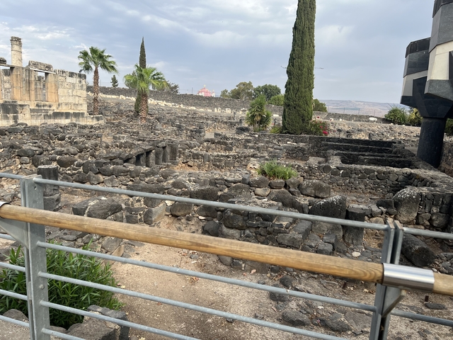       Area with historic stone walls and palm trees.
  
