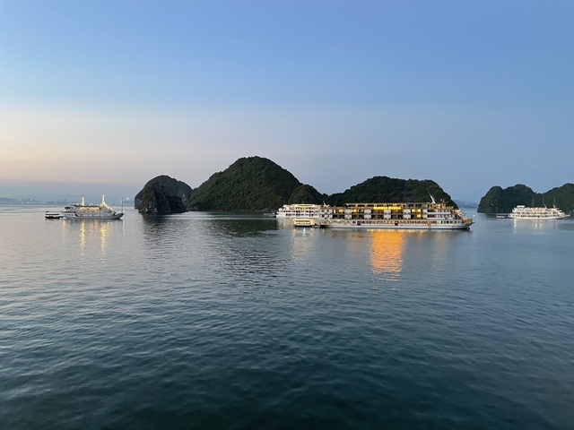       Cruise ships on calm water under clear skies.
  