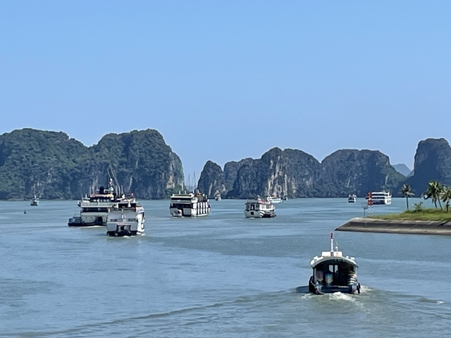       Boats sailing in a bay with limestone formations.
  