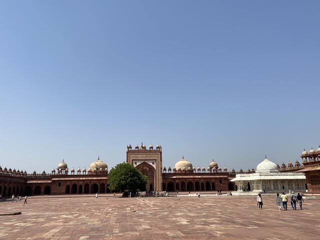       Courtyard of a grand palace with multiple domes.
  