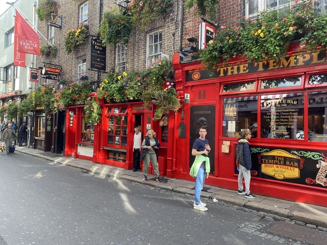 Colorful pub front of the Temple Bar in Dublin with people outside.